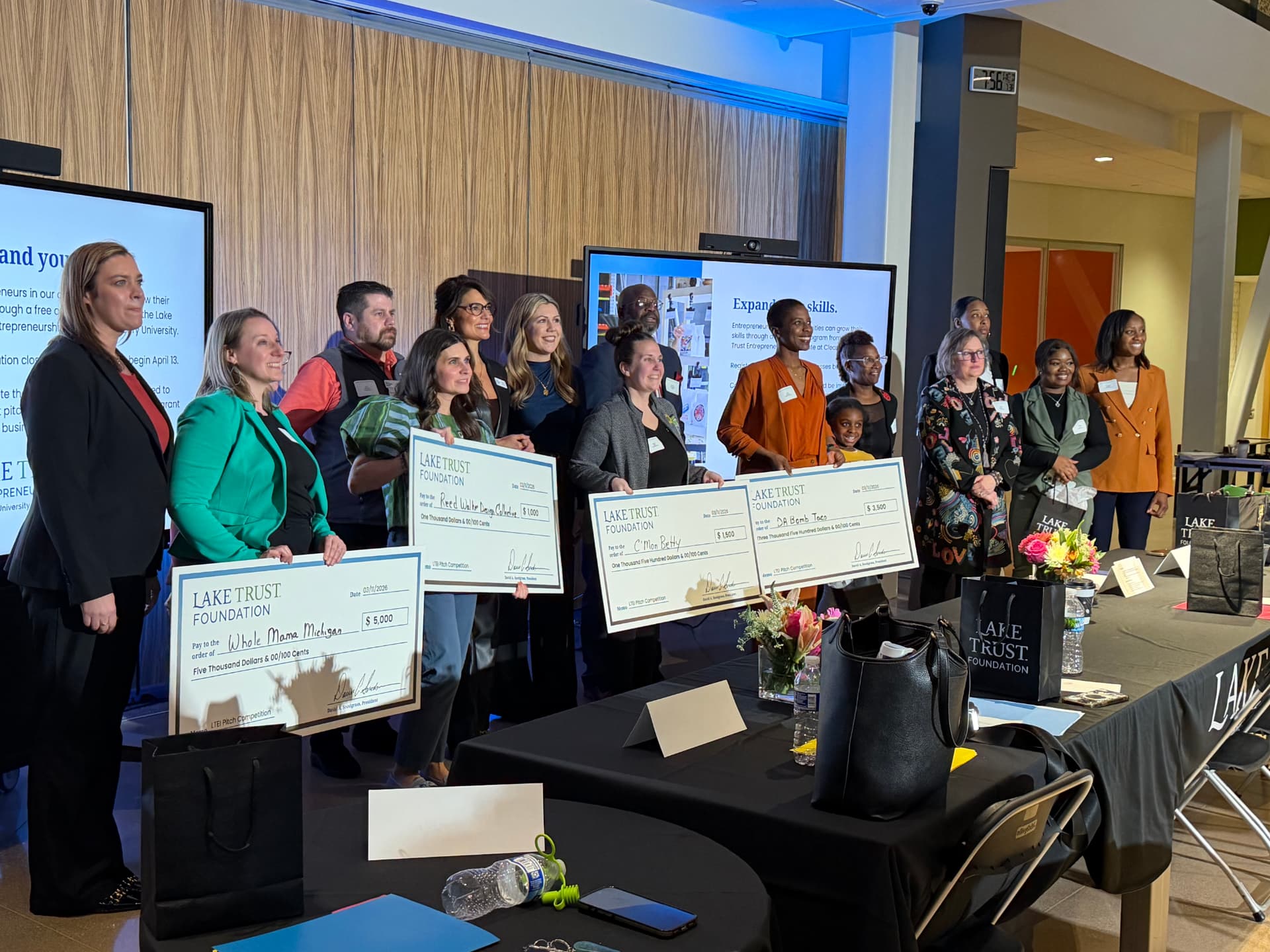 Emily Stone-Aiello holding the grand-prize check for Whole Mama Michigan at the Lake Trust Foundation Entrepreneur Pitch Competition